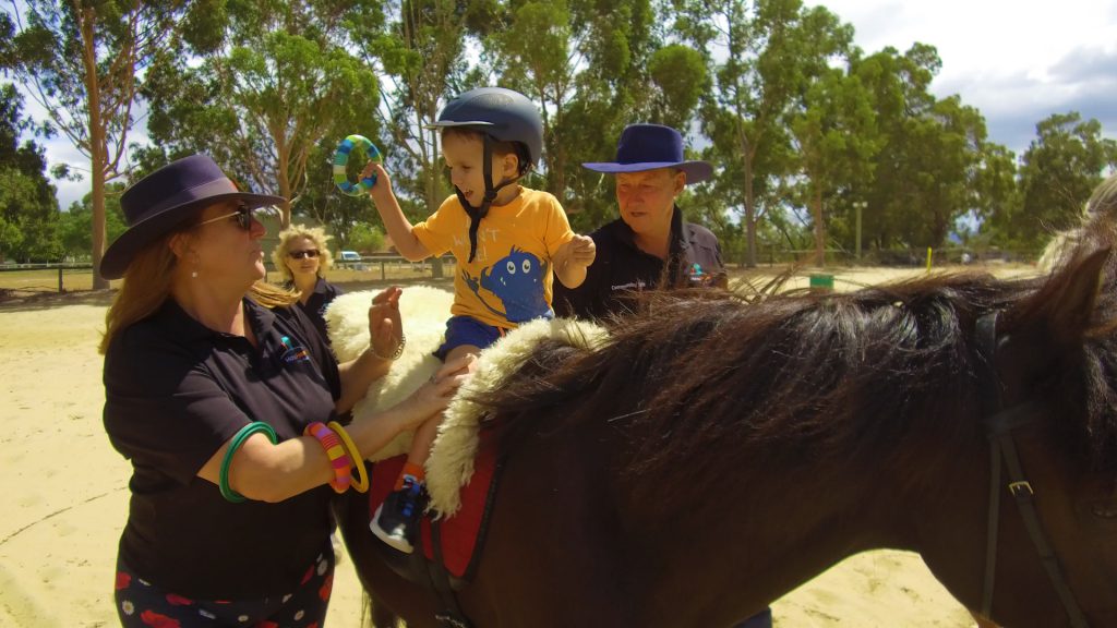 Jaxon riding with assistance from HorsePower volunteers